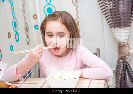 Kind ißt, chinesische Nudeln für die Tabelle, Einweggeschirr, Essstäbchen, Stockfoto