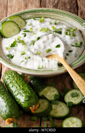 Indische pikanter Sauce raita mit Kräutern und Gurke close-up in einer Schüssel auf dem Tisch. Vertikale Stockfoto