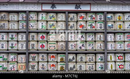 Sehr große Display von Reis sake Fässer mit bunten Labels in hölzernen Regalen neben Tsurugaoka Hachimangū Shinto Schrein in Kamakura Japan geschmückt. Stockfoto