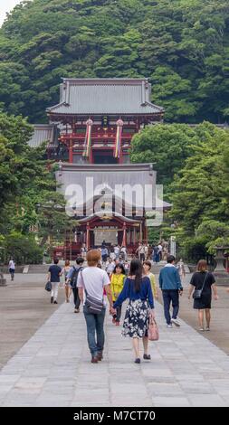 Japanisches paar Stein Weg zu Fuß bis zum Eingang der Tsurugaoka Hachimangū Schrein in Kamakura Japan mit einer großen Gruppe von Touristen im Hintergrund. Stockfoto