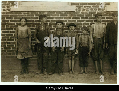 Dieses Foto zeigt Arbeiter, die in den Clayton Cotton Mills in North Carolina arbeiten. Die Szene fängt die Pünktlichkeit und den Fleiß der Arbeiter ein, während die Morgenschicht beginnt, während die Pfeife weht. Mr. W.H. Swift wird als Figur in der Gemeinde erwähnt. Stockfoto