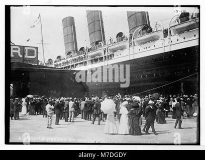 Ein Nahfoto der RMS Lusitania, die am Dock in New York City ankommt und die Steuerbordseite des Schiffes und die Zuschauer am Tatort erfasst. Dieses historische Bild bietet einen detaillierten Blick auf das ikonische Schiff. Stockfoto