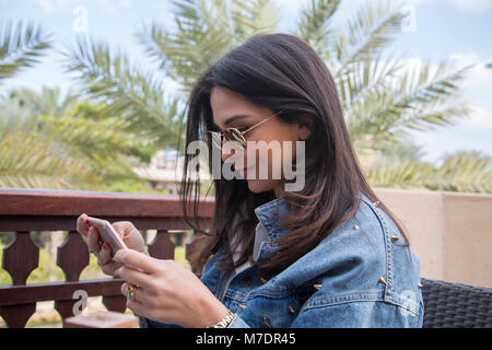 Seitenansicht einer jungen Frau Bilder, die mit einem Smart Phone im Freien Stockfoto