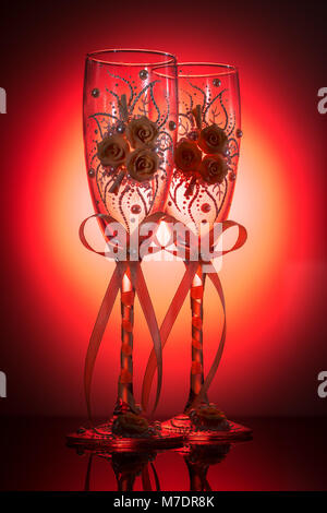 Das schön eingerichtete Hochzeit champagne Weingläser auf rotem Hintergrund Stockfoto