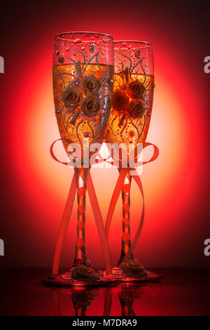 Das schön eingerichtete Hochzeit champagne Weingläser auf rotem Hintergrund Stockfoto