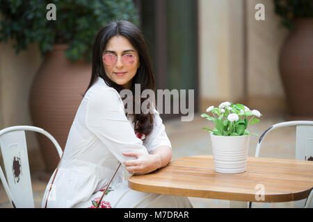 Schöne Frau mit Sonnenbrille saßen in einem Cafe im Madinat Jumeirah Souk Dubai UAE Stockfoto