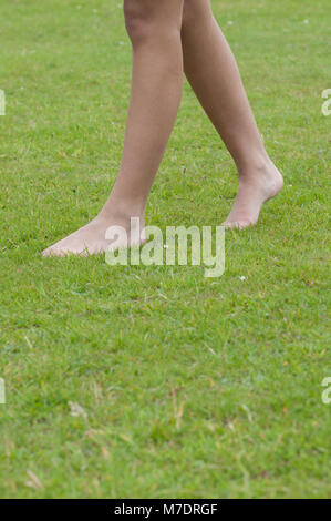 Nahaufnahme von einem barfüssigen Jungen Frau zu Fuß auf dem Gras Stockfoto