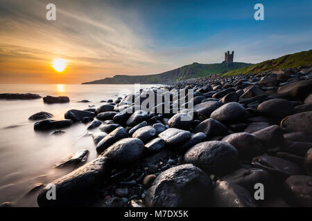 Dunstanburgh Castle in Northumberland über die berühmten Felsbrocken in Embleton Bay. Stockfoto