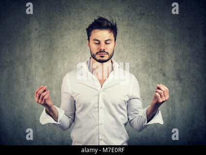 Stattliche casual Bart Mann hält die Hände in Meditation und halten die Augen geschlossen. Stockfoto