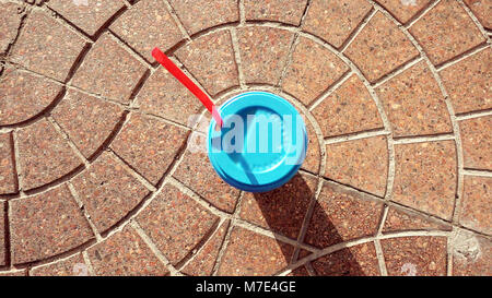 Pappbecher mit blauer Verschlusskappe und roten Trinkhalm. Stockfoto