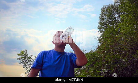 Mann trinkt frisches Wasser aus einer Plastikflasche Stockfoto
