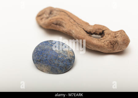 Lapislazuli ist ein tiefes Blau metamorphes Gestein als Halbedelstein auf weißem Hintergrund mit altem Holz Stockfoto