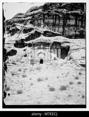 Ein Foto eines Grabes in Petra, einer antiken Stadt in Jordanien, mit drei Urnen. Petra ist bekannt für seine in Felsen gehauene Architektur und das Wasserleitungssystem, was es zu einer der berühmtesten archäologischen Stätten der Welt macht. Stockfoto