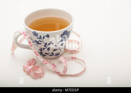 Tasse heißer schwarzer Tee mit Maßband über einen weißen Hintergrund mit Kopie Raum in ein Konzept von Gewichtsverlust und eine gesunde Ernährung Stockfoto