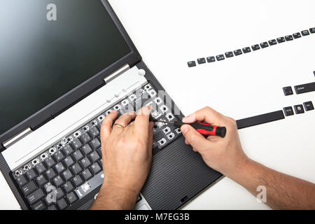 Techniker heben die Beschriftung der Tasten auf der Tastatur eines offenen Laptop Computer in einem Reparatur- oder Wartungsarbeiten Konzept Stockfoto