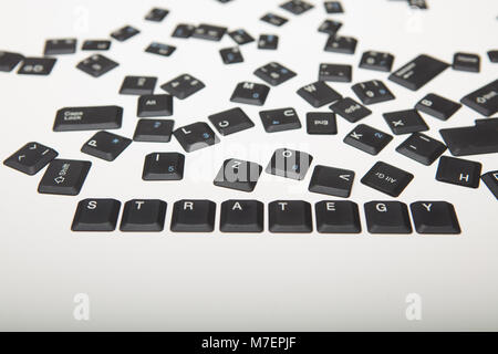 Die Tastatur besteht aus lose Schlüssel Abdeckungen von einem Computer mit dem Wort Strategie und Ziffern in der Nähe zu hohen Winkel konzeptionelle anzeigen Stockfoto