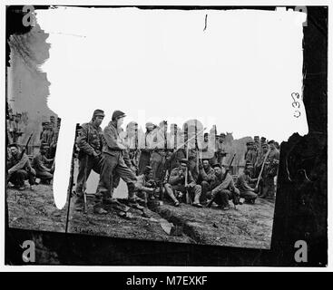 Eine Gruppe von Soldaten nimmt an einer Maisernte Teil, wobei die landwirtschaftlichen Anstrengungen während des Krieges und die Rolle des Militärs bei nicht-Kampfeinsätzen hervorgehoben werden. Stockfoto