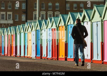 Bunte Strandhütten direkt an der Meeresküste von Brighton, East Sussex, England. Stockfoto