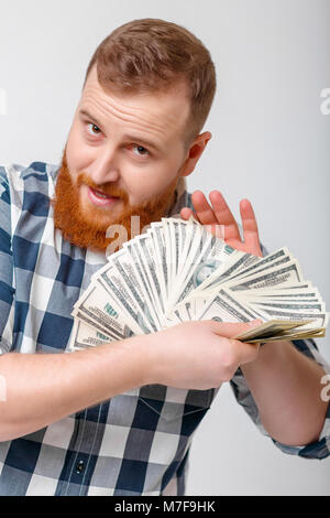 Junge schöne lächelnden Mann mit Bart in Plaid Shirt Holding eine Menge 100-Dollar-Scheine. Geld Stockfoto