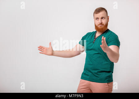 Junger Mann in Grün Shirt, Größe von etwas Stockfoto