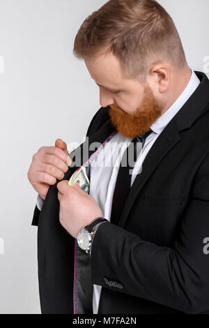 Elegante erfolgreicher Mann in Anzug, Dollar Geldscheine aus Anzug Tasche Stockfoto