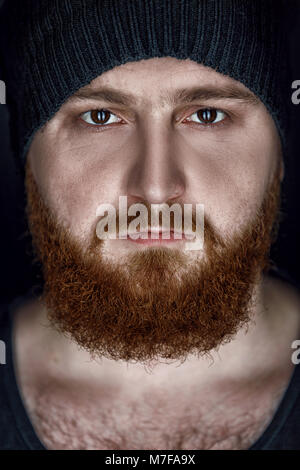 Close-up Portrait von Red bärtigen Mann in hat auf schwarzem Hintergrund Stockfoto