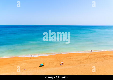 Touristen Sonnenbaden am idyllischen Strand in Armacao de Pera, Algarve, Portugal Stockfoto