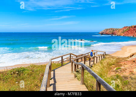 Junge Frau touristische Fuß zu Amado Strand am Holzsteg, Algarve, Portugal Stockfoto