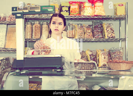 Junge Frau prüft das Gewicht eines Paketes von Cookies in den Store Stockfoto