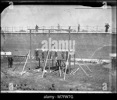 Dieses Foto zeigt die Hinrichtung der Verschwörer, die an der Ermordung von Präsident Abraham Lincoln beteiligt waren, und zeigt ihre Leichen, die im Hof hängen, während Wachen anwesend sind. Stockfoto