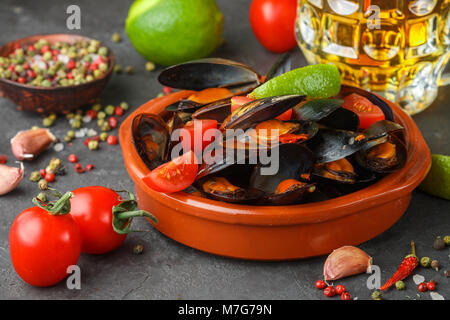 Muscheln in Tanks mit Tomaten und würziger Sauce aus Chili und Knoblauch. Leckeren Snack zum Bier. Mediterrane Gerichte. Selektiver Fokus Stockfoto