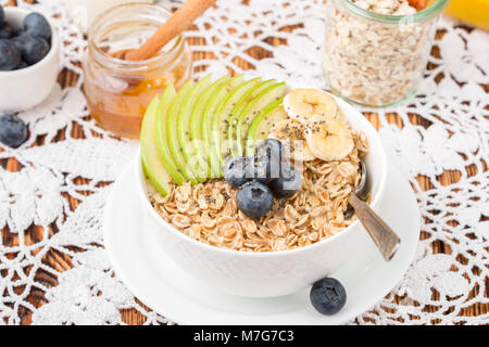 Haferflocken mit grünem Apfel, Banane, Blaubeeren, Honig und Chia Samen. Gesundes Frühstück. Im rustikalen Stil. Selektiver Fokus Stockfoto
