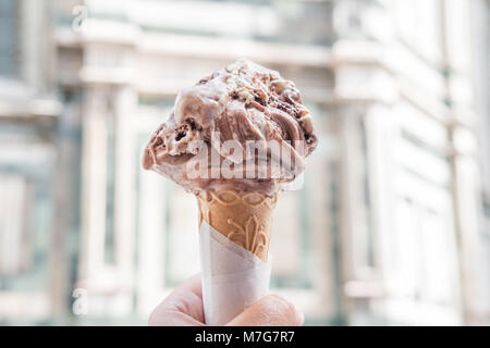 Hand Gelato mit unscharfen Florenz Duomo auf Hintergrund, eine der bekanntesten Sehenswürdigkeiten in Italien in den Hintergrund. Stockfoto