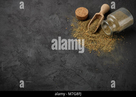 Zaatar - Mischung aus orientalischen Gewürzen auf einem dunklen Stein Hintergrund. Gewürze aus getrockneten Kräutern hergestellt, mit Sesam, Sumach, Salz und anderen Gewürzen gemischt. Zu Stockfoto