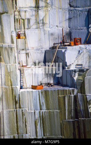 Handwerker stehen in der Nähe der Kante eines steilen und gefährlichen Fallen, wie Sie granitblöcke an den Felsen der alter Steinbruch in Barre, Vermont, United States, Stockfoto