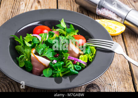 Salat mit Parmaschinken (jamon), Tomaten und frischen Kräutern Stockfoto