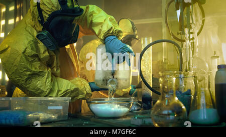 In der U-Bahn zwei illegale Droge Labor Chemiker abgedeckt im schützenden Schutzanzüge und Gasmasken Mix Chemikalien zu Drogen synthetisieren. Stockfoto