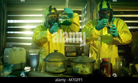 In der U-Bahn zwei illegale Droge Labor Chemiker das Tragen von Schutzmasken und Overalls Test gekocht der Droge Reinheit und Stärke. Stockfoto