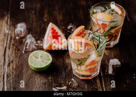 Von oben Gläser frische Grapefruit Wasser mit Rosmarin auf Holztisch. Stockfoto
