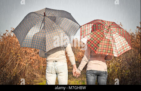 Junges Paar unter einem Regenschirm in den Wald Stockfoto
