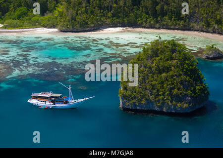 Ein Bugis schooner, live-aboard dive Schiff vor Anker in einem Kalkstein Insel Lagune, uranie Insel, Raja Ampat, West Papua, Indonesien. Stockfoto