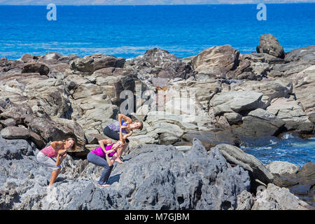 Drei Frauen (HERR) Vor der Ozean in einem Yoga Position, Kapalua Bay, Maui, Hawaii, USA. Stockfoto