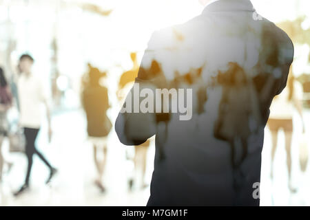 Doppelbelichtung Geschäftsmann in dunklen grauen Anzug stehen und überqueren den Arm gerade Weltwirtschaft Situation und in Vision im globalen Geschäft Stockfoto