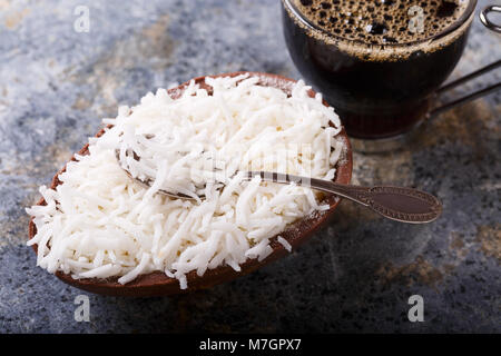 Ei Schokolade mit Füllung aus Kokos für Ostern und die Tasse Kaffee. Selektiver Fokus Stockfoto