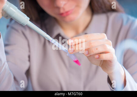 Technikerin mit Pipette in Kop für DNA die gerichtliche Prüfung Stockfoto