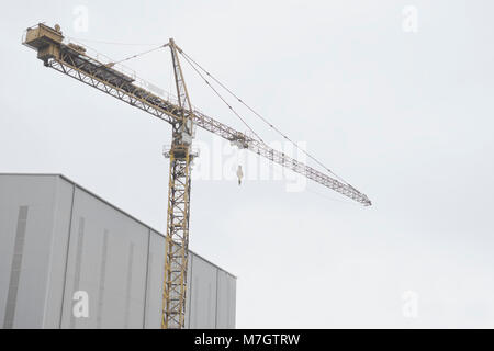 Einzelnen hohen Turm Kran bei Bau Baustelle über den Schiffbau Werk Stockfoto