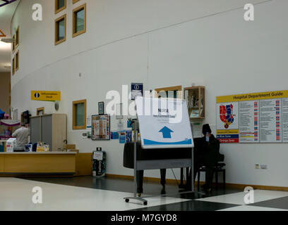 Eine Krankenschwester Rekrutierung Zeichen ist neben einem Pianisten in der Haupteingang des Queen's Krankenhaus in Romford angezeigt, in East London am 10. März 2018. Stockfoto