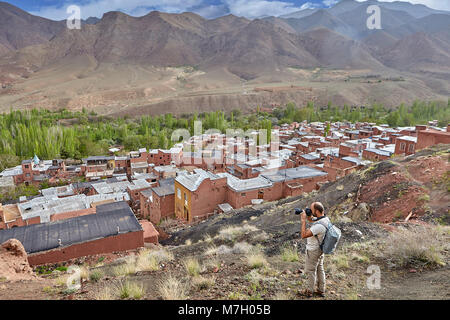 Dorf Abyaneh, Provinz Isfahan, Iran - 26. April 2017: Ein einsamer Wanderer Fotos die Dächer der alten Berg Dorf mit Häusern aus rotem c Stockfoto