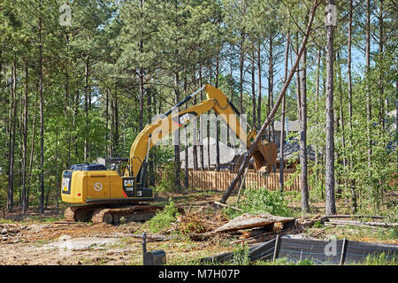 Digger oder Bagger clearing Land für den Bau neuer Gebäude in Hecht Straße Alabama, USA. Stockfoto