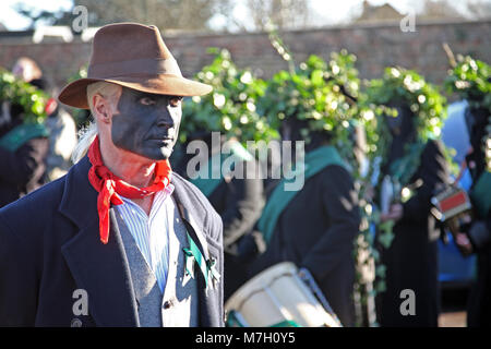 Morris Tänzer mit abgedunkelten bis Gesicht an Whittlesey Stroh tragen Festival, Cambridgeshire, Großbritannien. Stockfoto